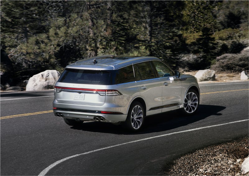 A 2023 Lincoln Aviator® Grand Touring model is shown being driven on a tight turn of a mountain road | Mike Carpino Lincoln in Pittsburg KS