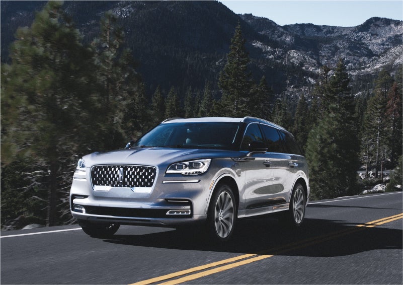 A 2023 Lincoln Aviator® Grand Touring SUV being driven on a winding road to demonstrate the capabilities of all-wheel drive | Mike Carpino Lincoln in Pittsburg KS