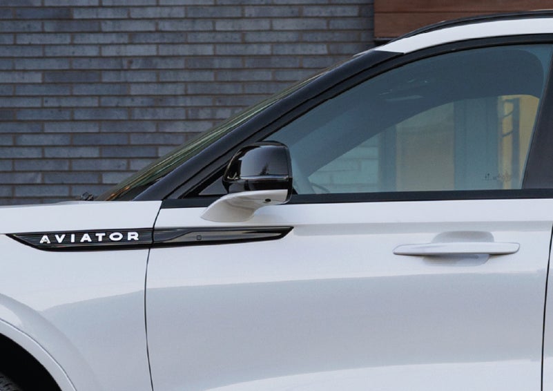 The driver’s side door and fender badging of a white 2026 Lincoln Aviator® SUV are showcased. | Mike Carpino Lincoln in Pittsburg KS