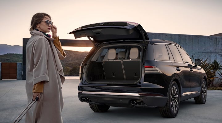 A woman approaches a 2026 Lincoln Aviator® SUV with its rear liftgate open. | Mike Carpino Lincoln in Pittsburg KS