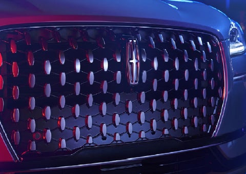 The grille of a 2025 Lincoln Corsair&reg; SUV reflects neon light at night. | Mike Carpino Lincoln in Pittsburg KS