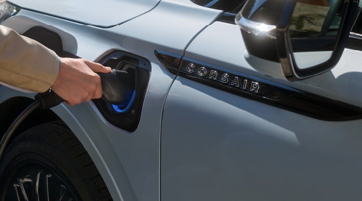 A hand is plugging in a 2026 Lincoln Corsair® Grand Touring Plug-in Hybrid SUV. | Mike Carpino Lincoln in Pittsburg KS