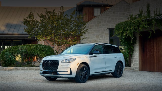 A 2026 Lincoln Corsair® SUV is parked in front off a luxury home. | Mike Carpino Lincoln in Pittsburg KS