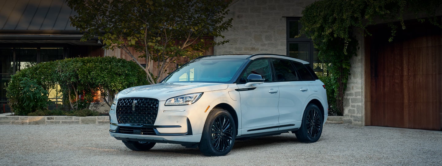 A 2026 Lincoln Corsair® SUV is parked in front off a luxury home. | Mike Carpino Lincoln in Pittsburg KS