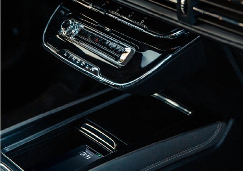 A smartphone rests on the available wireless charging pad in the front center console cubby | Mike Carpino Lincoln in Pittsburg KS