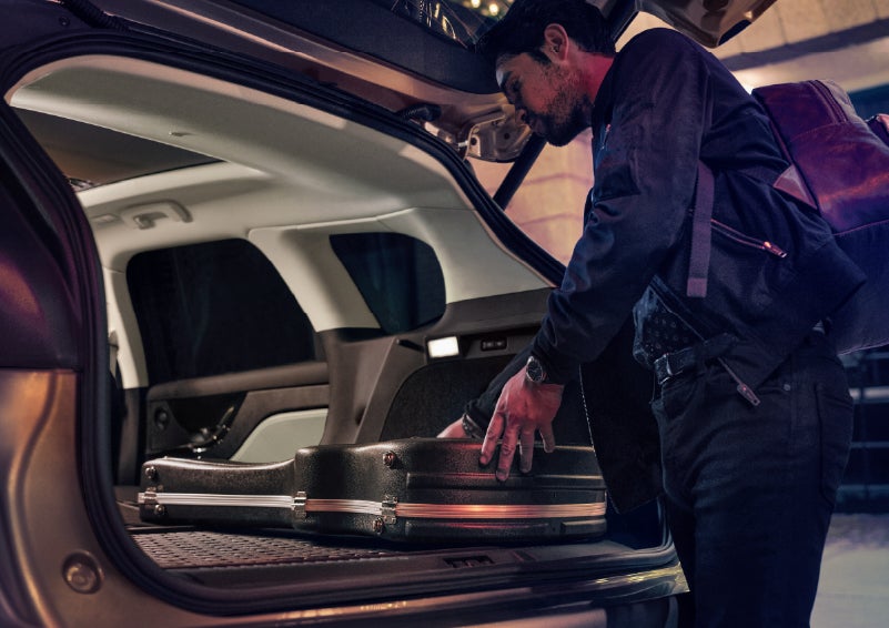 A man is shown loading cargo into the rear of a 2026 Lincoln Corsair® SUV with the second-row seats folded flat. | Mike Carpino Lincoln in Pittsburg KS