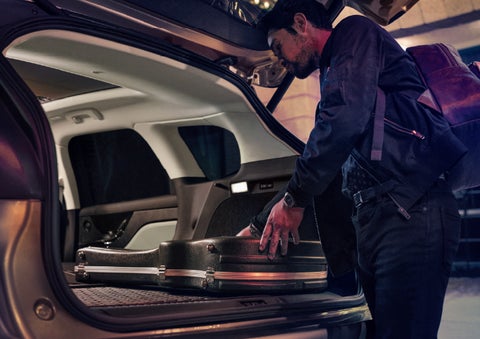 A man is shown loading cargo into the rear of a 2026 Lincoln Corsair® SUV with the second-row seats folded flat. | Mike Carpino Lincoln in Pittsburg KS
