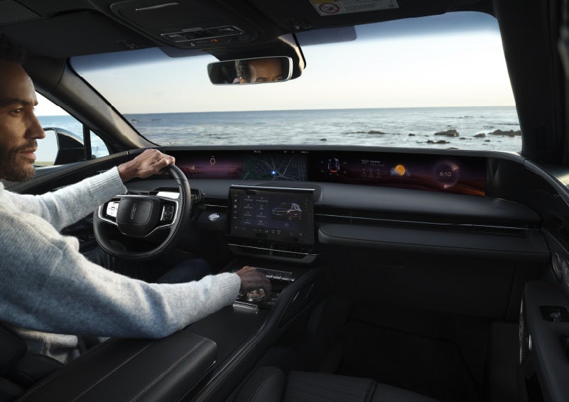 A driver of a parked 2026 Lincoln Nautilus® SUV takes a relaxing moment at a seaside overlook while inside his Nautilus. | Mike Carpino Lincoln in Pittsburg KS