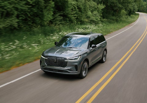 A 2027 Lincoln Aviator® SUV is being driven down a road. | Mike Carpino Lincoln in Pittsburg KS