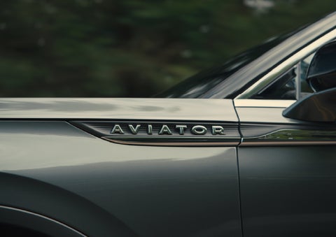 The driver’s side door and fender badging of a gray 2027 Lincoln Aviator® SUV are showcased. | Mike Carpino Lincoln in Pittsburg KS