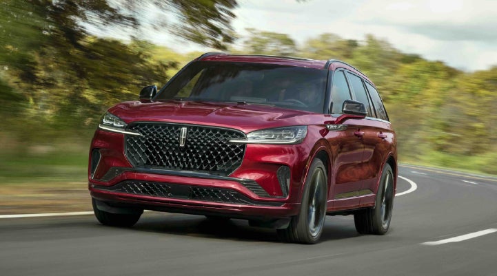 A 2027 Lincoln Aviator® SUV is being driven on a country road | Mike Carpino Lincoln in Pittsburg KS