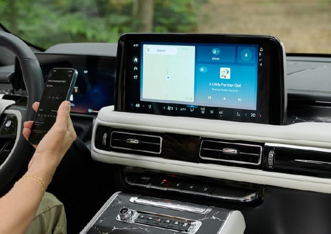 A person pairs thier phone with the center touchscreen of a 2027 Lincoln Aviator® Black Label™ SUV | Mike Carpino Lincoln in Pittsburg KS